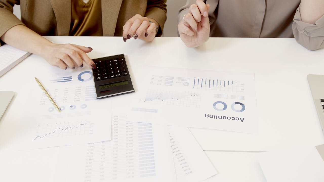 heros-img Two professionals analyzing financial documents with a calculator.